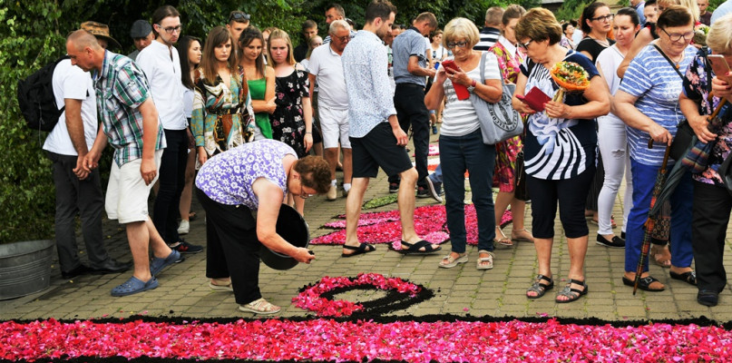 Na zdjęciu Maria Pełka - prezes Stowarzyszenia Spycimierskie Boże Ciało usypująca obrazy kwietne.