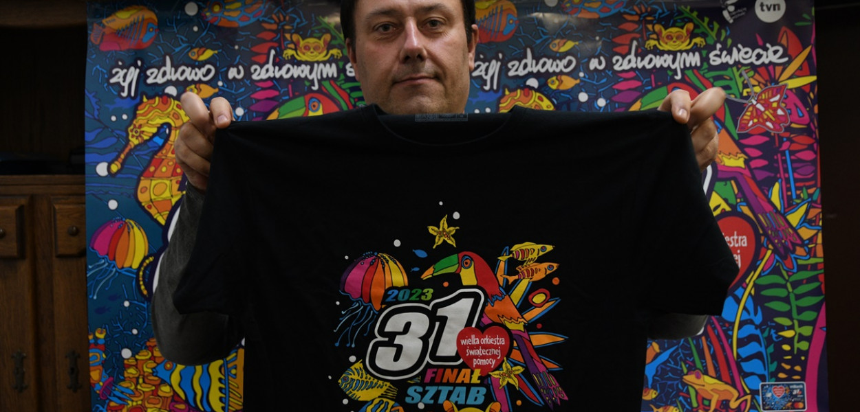 Na zdjęciu Marcin Jaśkiewicz z uniejowskiego sztabu WOŚP z jedną z koszulek wystawionych na licytację.