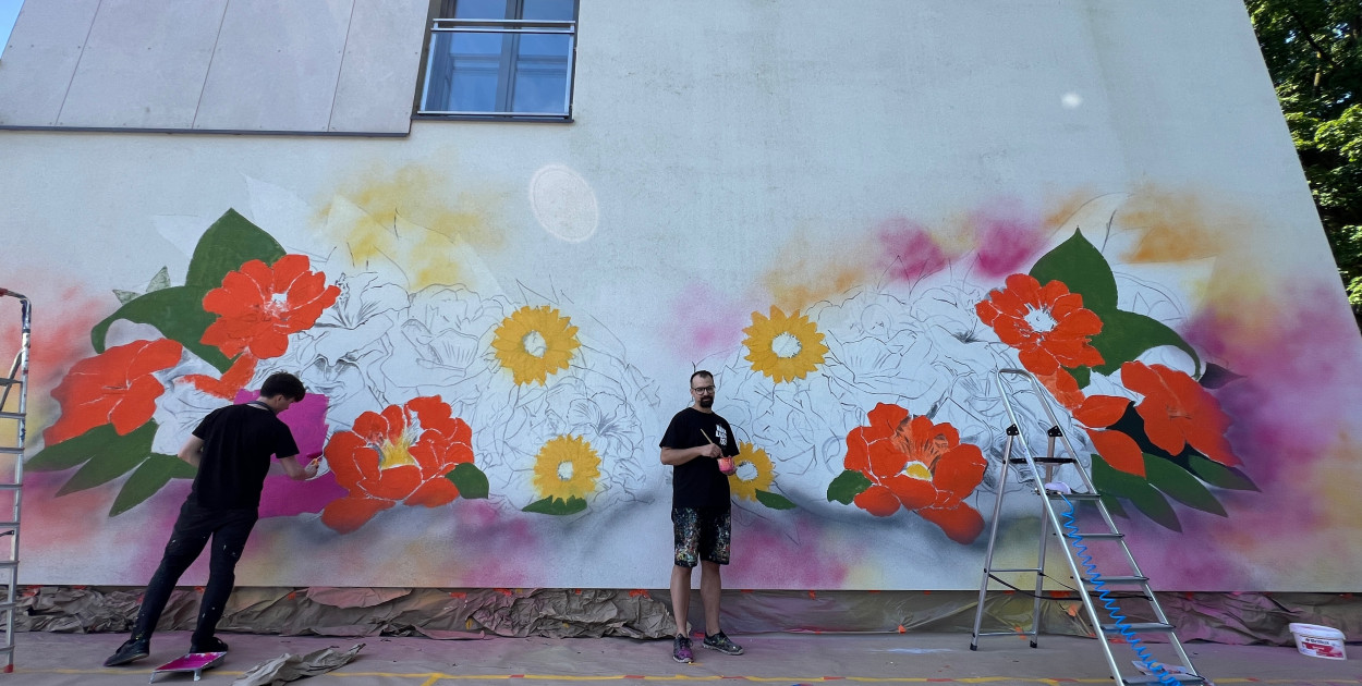 W ten weekend na północnej ścianie Aparthotelu Termy Uniejów powstają kwiatowe skrzydła, czyli mural nawiązujący do tradycji układania kwietnych dywanów w pobliskim Spycimierzu podczas święta Bożego Ciała.